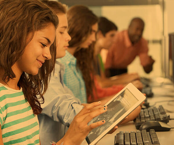 Les nouvelles technologies en salle de classe. Une jeune fille qui se sert d'une tablette en salle de classe.