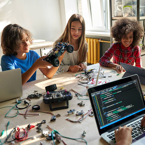 un groupe d’élèves autour d’une table qui construisent des robots.