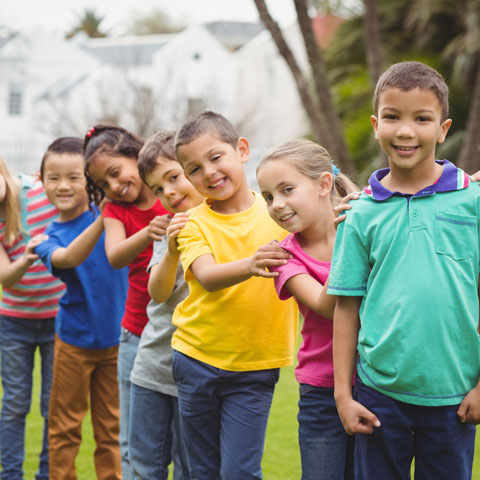 Groupe de jeunes enfants en ligne à l’extérieur.