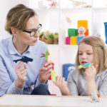 Une éducatrice et une élève qui utilise des jouets pendant la thérapie par le jeu
