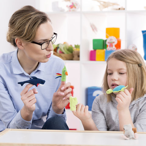 Une éducatrice et une élève qui utilise des jouets pendant la thérapie par le jeu