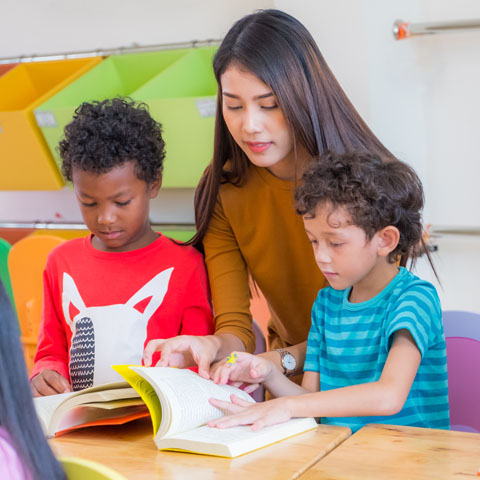 Une enseignante et des élèves en classe faisant de la lecture.