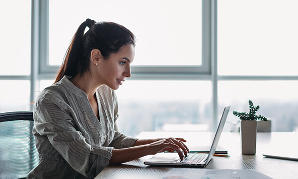 Une jeune femme qui suit la formation «PACFOSS» en ligne.